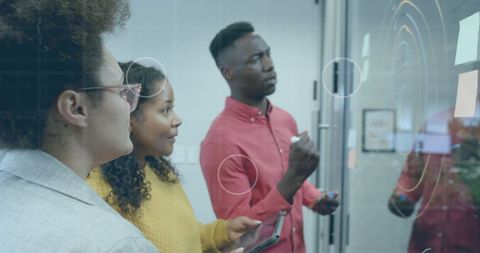 Diverse Team Analyzing Data on Transparent Screen
