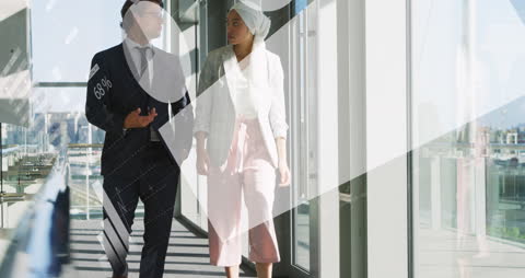 Diverse Business Team Analyzing Data Insights in Office Corridor