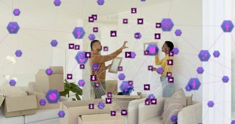 Couple discussing apartment move with tablet and moving boxes with digital network overlay