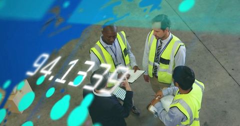 Warehouse operations team reviewing digital logistics data and floor plans with tablet and clipboard
