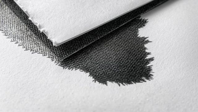 Displaying overlapping deckled papers with black crosshatch ink texture, print still life