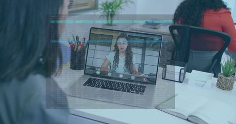 Virtual team collaborating via laptop video call with software code overlay on office desk