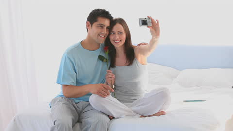 Romantic Couple Taking a Selfie with Rose in Bedroom