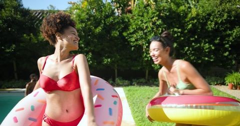 Diverse Friends Enjoying Pool Fun with Colorful Floats