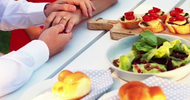 Engaged Couple Holding Hands During Outdoor Meal Celebration - Download Free Stock Images Pikwizard.com