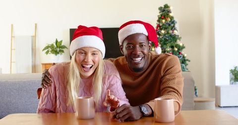 Happy Couple in Santa Hats Enjoying Christmas at Home