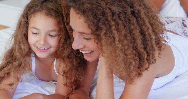 Mother and Daughter Lying on Bed Laughing Together - Download Free Stock Images Pikwizard.com
