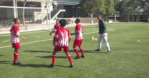 Youth soccer team receiving coaching on field demonstrates teamwork