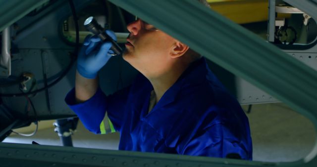 Aircraft Maintenance Worker Inspecting Interior with Flashlight - Download Free Stock Images Pikwizard.com