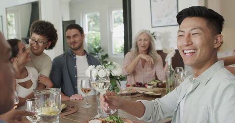 Friends Toasting with Drinks at Wedding Celebration in Dining Room