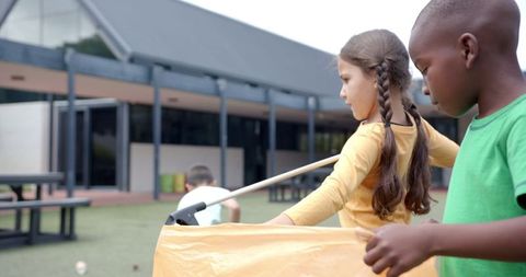 Children collecting litter at school to promote environmental responsibility