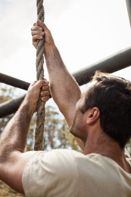 Military soldier training rope climbing at boot camp