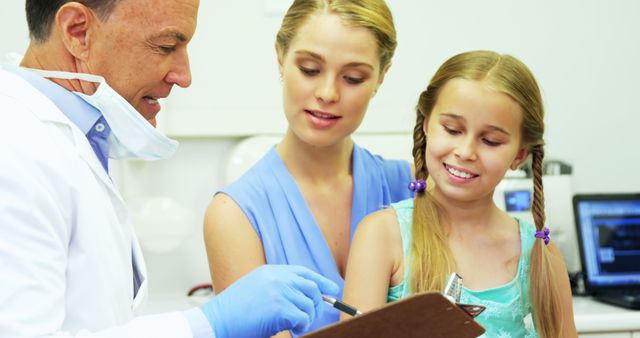 Doctor Explaining Medical Details to Mother and Daughter in Clinic - Download Free Stock Images Pikwizard.com