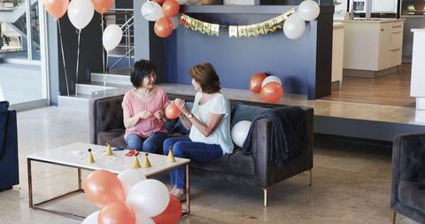 Senior women preparing for birthday celebration with balloons