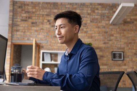Professional Man Using French Press in Modern Office