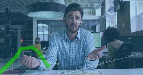 Manager gesturing and explaining falling financial chart with digital overlay in office