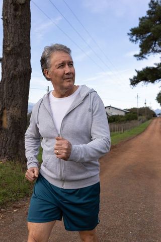 Mature Man Jogging on Rural Dirt Road Promoting Outdoor Fitness and Wellness