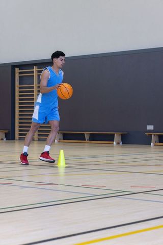 Basketball athlete focused on ball control drills indoors