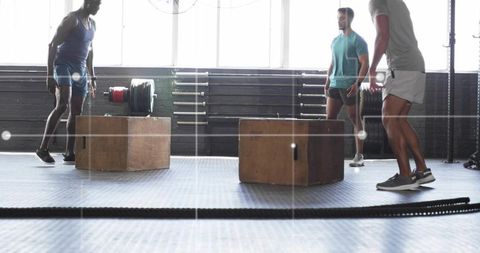 Men Performing Box Jumps in CrossFit Gym for Strength Training