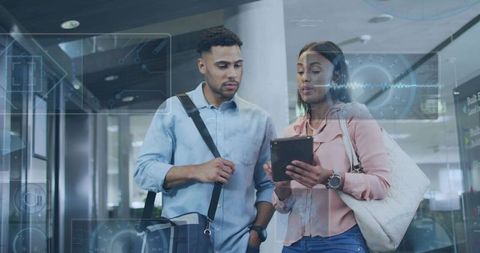Business Travelers Reviewing Digital Plans on Tablet with Futuristic HUD at Airport