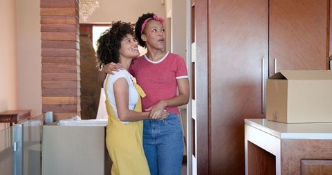 Joyful Female Couple Laughing and Embracing at Home