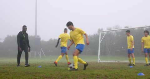Foggy Soccer Practice with Coach and Young Players