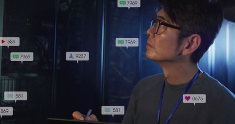 Asian Engineer Analyzing Data Server with Social Media Notifications