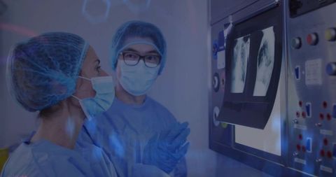 Medical Team Reviewing Chest X-Rays in Radiology Lab with Digital Monitor and Sterile Gear