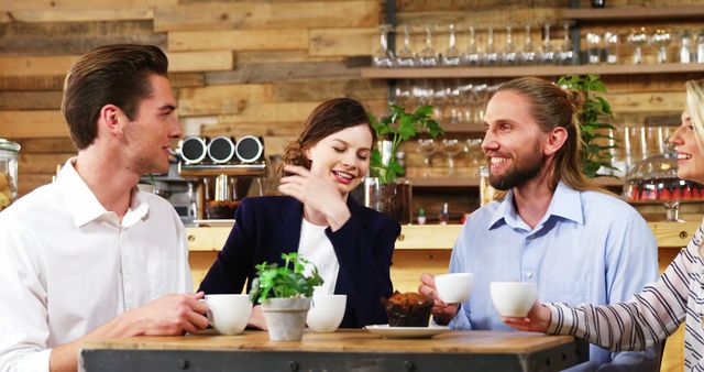 Diverse Group of Young Professionals Enjoying Coffee in Modern Cafe - Download Free Stock Images Pikwizard.com