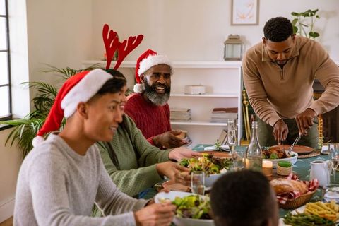 Festive Family Celebrating Holiday with Dinner and Santa Hats