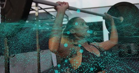 Woman pulling chin-up while lifting barbell with teal particle overlay