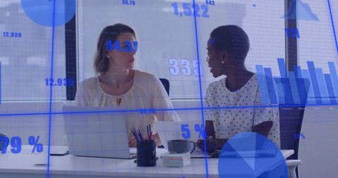Collaborating Women at Office Desk with Data Visualization Overlay and Charts