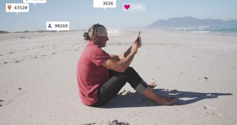 Mature man live streaming on beach with social media icons