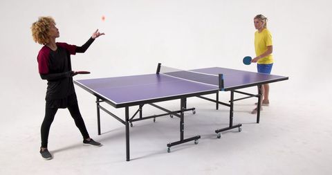 Diverse Female Opponents Playing Table Tennis in Studio Setting