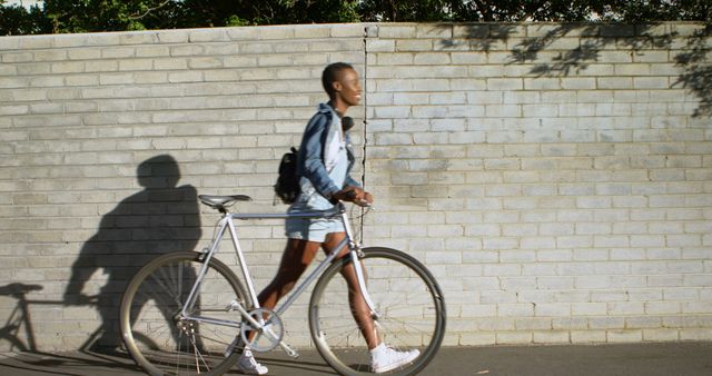 Young Woman Walking Bicycle Along Brick Wall - Download Free Stock Images Pikwizard.com