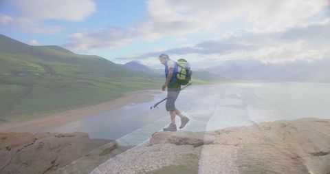 Solitary Hiker Walking Along Edge of Coastal Cliff