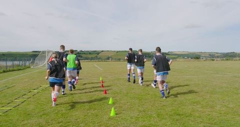 Soccer Players in Training Drills on Sunny Pitch