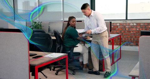 Colleagues collaborating over tablet in modern open-plan office with digital overlay