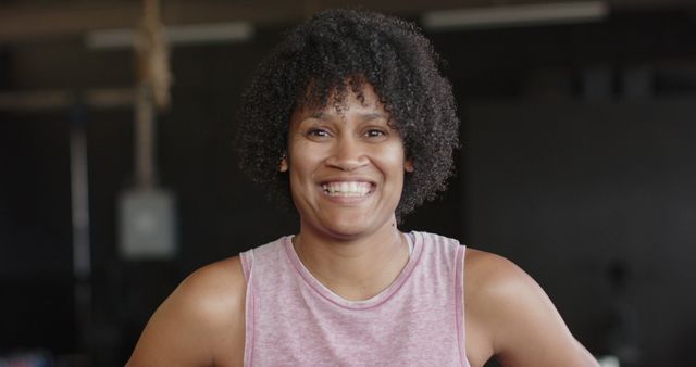 Portrait of happy african american woman at gym in slow motion. Lifestyle, fitness, activity and confidence.