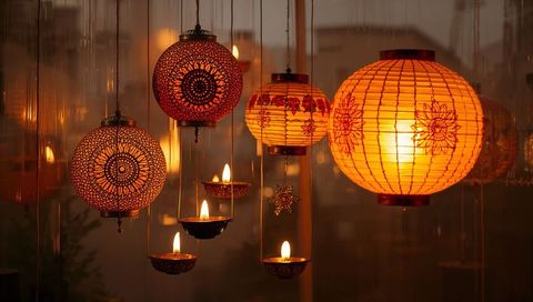 Hanging ornate lanterns and oil lamps casting warm amber glow in shop window