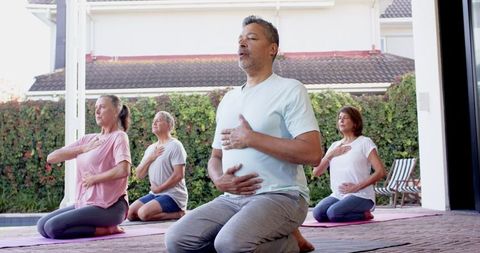 Diverse group breathing exercises outdoors in harmony