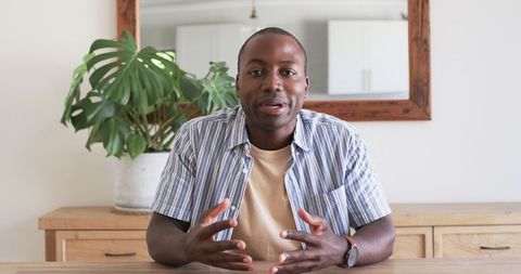 Smiling African American Husband Engaged in Video Call at Home