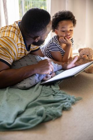 Father and daughter bonding through tablet technology at home