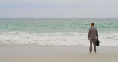 Businessman with Briefcase Contemplating Ocean at Seashore - Download Free Stock Images Pikwizard.com