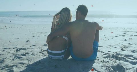Sunlit Couple Embracing on Sandy Beach at Shoreline with Pastel Backlight and Lensflare