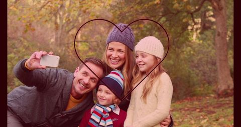 Happy Family Taking Selfie with Neon Heart Outdoors