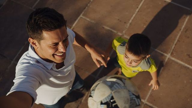 Father and Son Taking Selfie While Playing Soccer on Sunlit Terracotta Terrace