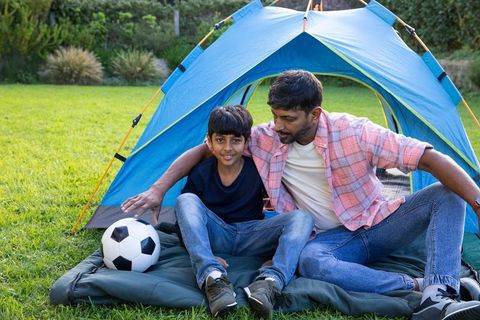 South Asian Father and Son Camping with Soccer Ball in Countryside