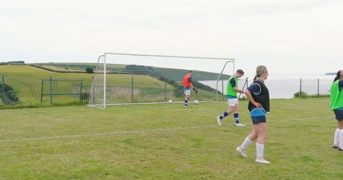 Soccer Practice by Coastal Landscape with Diverse Team