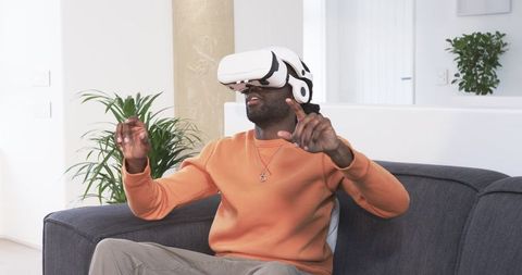 African American Man Experiencing Virtual Reality on Modern Sofa, Lifestyle Home Immersion
